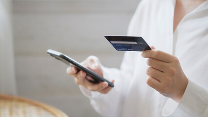 Young Asian woman shopping on mobile phone with Credit card.