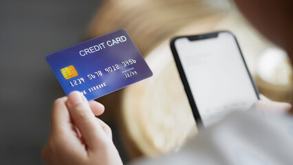 Young Asian woman shopping on mobile phone with Credit card.