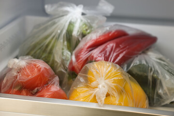 Plastic bags with different fresh products in refrigerator, closeup