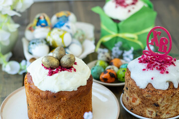 Top view on Easter wooden table with Easter cakes and colored eggs. topper Easter cakes with Russian letter XB means Christ is Risen. Happy easter concept. soft focus