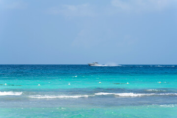 Seascape. Turquoise sea and clear blue sky. A motorboat rushes on the horizon