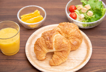朝食のクロワッサンとサラダとオレンジ