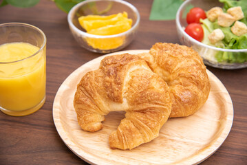 朝食のクロワッサンとサラダとオレンジ