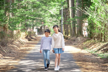 軽井沢の自然を手を繋いで歩くアジア人の子供