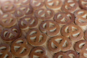 Pretzels sprinkled with sugar lie on a wooden surface