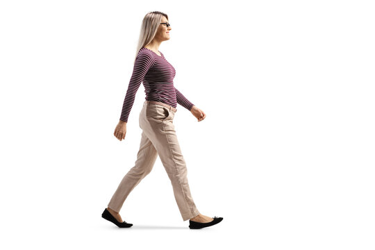 Full length profile shot of a casual blond young woman with glasses walking