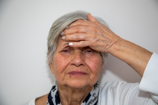 Serious Middle Aged Woman Touching Her Forehead and Thinking About Something. Sad Asian Woman With Gray Hair While Standing And Touching Her Forehead.