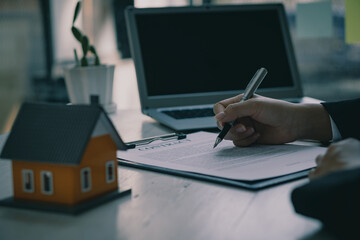 Real estate agent offices offer home sales contracts to customers at their desks.
