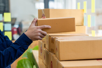 Small entrepreneurs start their SME business at home by arranging their products in yellow parcel boxes. The idea is to start selling online with laptops for taking orders and shipping.