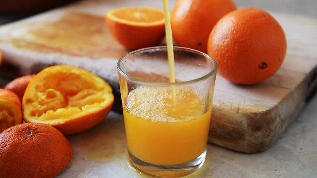 Pouring a glass of freshly squeezed orange juice.