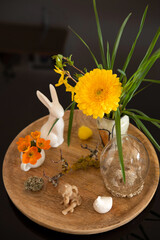 Easter scene with yellow and orange, spring flowers and decorative easter bunnies, angel and chicken