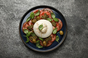 Delicious burrata salad on grey table, top view