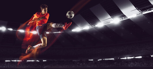 Bright dynamic collage with professional soccer, football player kick the ball in jump at dark...