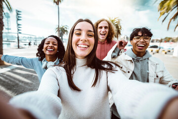 Young people taking selfie photo with smart mobile phone outside - Multicultural friends running on...