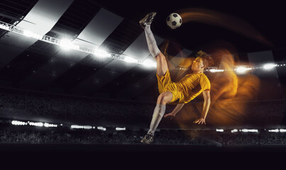 Bright dynamic collage with professional soccer, football player kick the ball in jump at dark night stadium with flashlights. Sport, competition, championship
