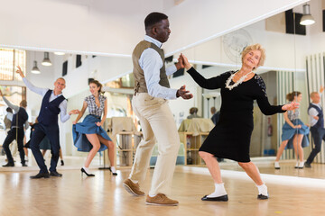 Senior womaSenior woman and man dancing swing in studion and man dancing swing in studio