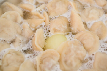 The process of making homemade dumplings. The dumplings are being cooked. The concept of traditional Russian cuisine