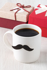 Father's day design concept. Close up of cup of coffee and gift box for daddy.