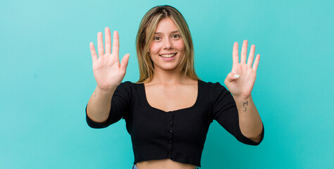 young pretty blonde woman smiling and looking friendly, showing number nine or ninth with hand...