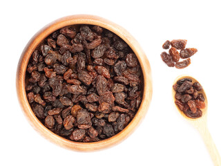 Raisin in wooden bowl and spoon, bunch isolated on white background. Macro. Healthy food concept