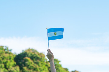 hand holding Argentina flag on nature background. 9th July of Independence day, 25th May of...