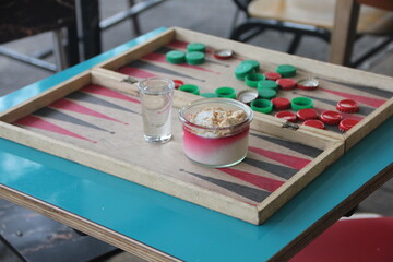 Malabi served with nuts and coconut shavings on a backgammon board 