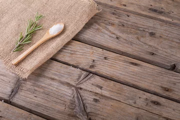 Foto op Canvas High angle view of rock salt in wooden spoon and rosemary on jute fabric at table with blank space © WavebreakMediaMicro