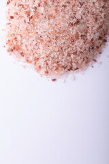 Close-up of himalayan pink rock salt on white background with copy space