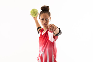 Portrait of biracial young female handball player throwing ball against white background