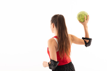 Rear view of caucasian young female handball player holding yellow ball against white background
