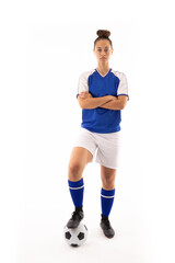 Portrait of biracial young female player standing with arms crossed and foot on soccer ball