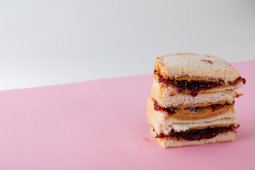 Close-up of stacked peanut butter and jelly sandwiches on table against gray background
