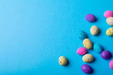 Colorful eater candies on blue background with copy space