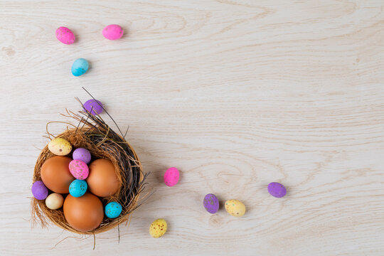 High angle view of eggs and colorful candies in nest on table during easter