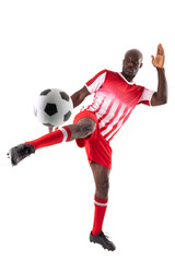 Fototapeta na wymiar Confident young male african american soccer athlete kicking ball against white background