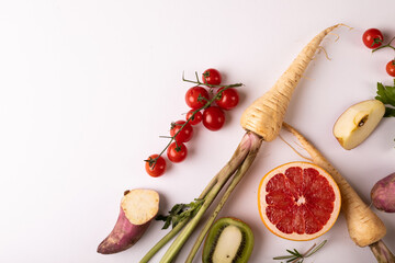 Directly above view of fresh vegetables and fruits by copy space on white background