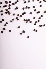 Directly above view of fresh chocolate chips scattered over copy space on white background