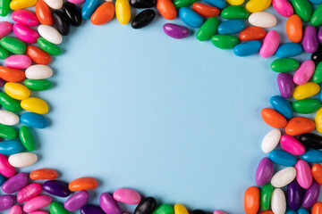 Directly above view of copy space amidst multi colored candies on blue background