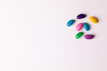 Directly above view of colorful sweet candies by copy space against white background