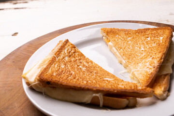 High angle view of fresh cheese sandwich served in plate on wooden serving board