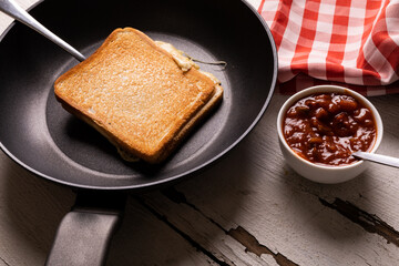 High angle view of fresh dip by cheese sandwich in cooking pan on wooden table