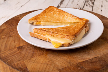 High angle close-up view of fresh cheese sandwich served in plate on wooden board