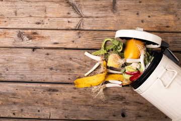 Directly above view of spilled organic waste from compost bin on wooden table