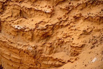 Textural sand, with  relief surface, multi-colored layers and different in size of granules, in outdoor sand career, after mining ore and sand for construction.