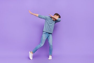 Photo of funny adorable guy wear grey shirt having fun dancing showing dab isolated violet color...