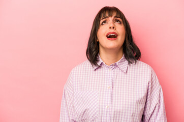 Young caucasian woman isolated on pink background shouting very angry, rage concept, frustrated.