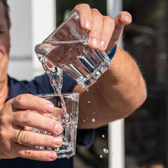Zwei Wassergläser in den Händen