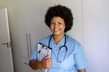 Portrait of smiling african american mid adult female nurse with stethoscope and clipboard