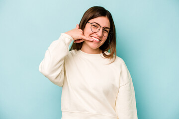 Young caucasian woman isolated on blue background showing a mobile phone call gesture with fingers.