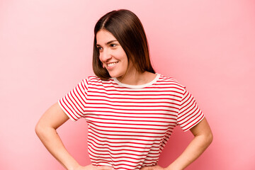 Young caucasian woman isolated on pink background confident keeping hands on hips.